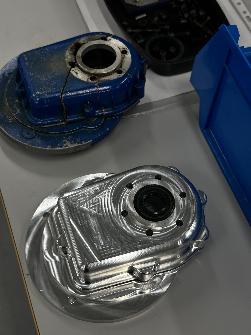 Damaged original housing next to the machined aluminium replacement